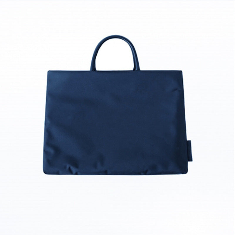 Dark blue waterproof nylon laptop bag on a white background in a product photo