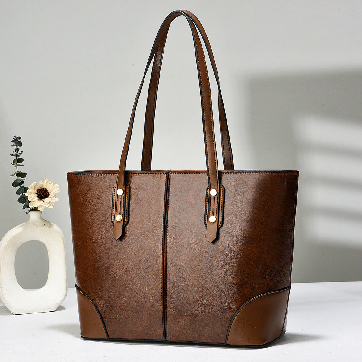 brown large women’s tote handbag front view with long shoulder straps and contrast stitching