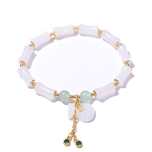white jade-effect bracelet with gold details and a dangling charm